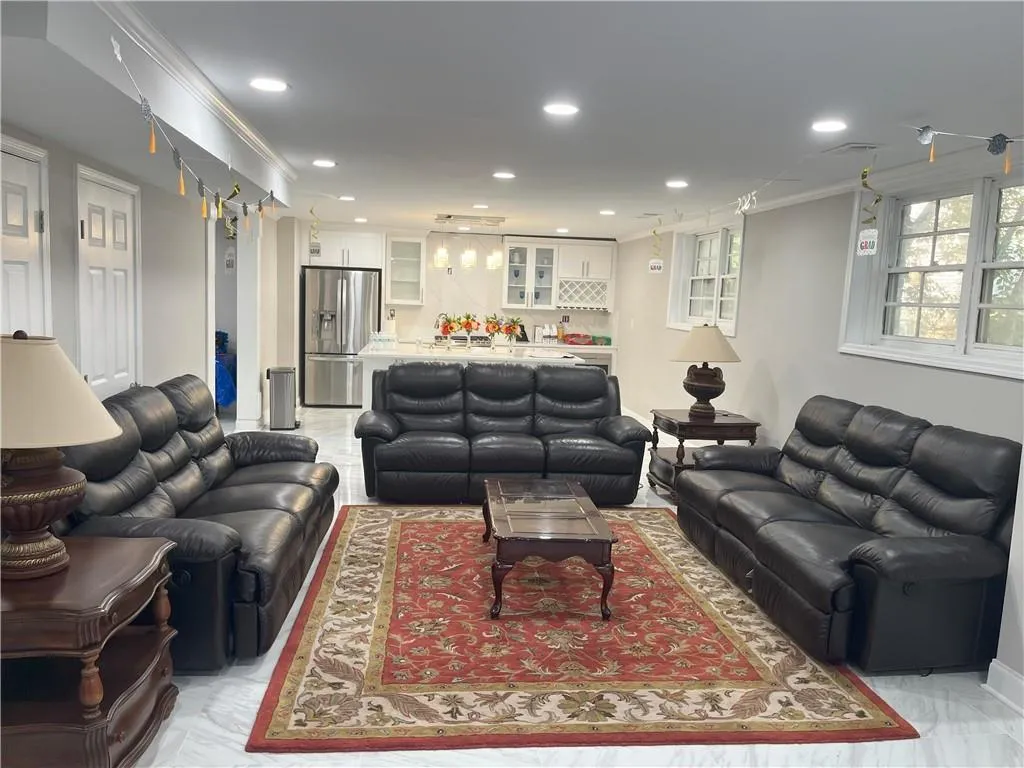 Living area featuring crown molding and recessed lighting