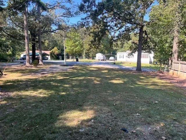 Expansive lot featuring mature trees and a partial wood fence