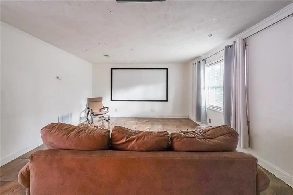 Cinema room featuring a textured ceiling and baseboards