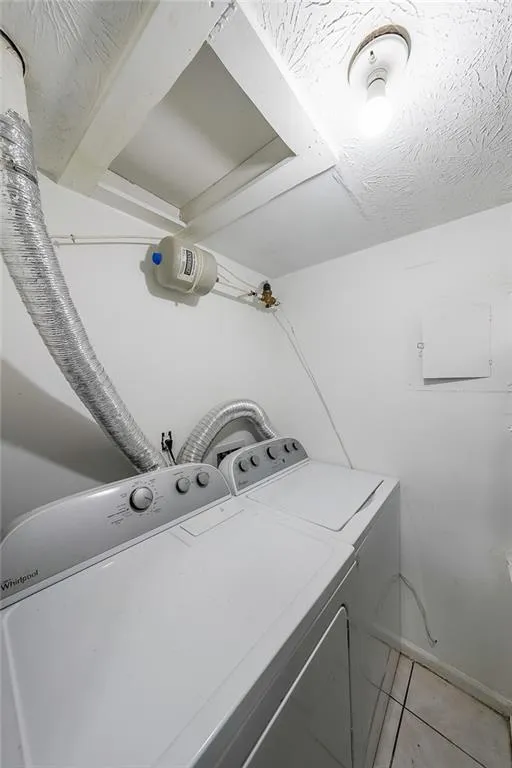 Laundry area featuring light tile patterned flooring and washer and dryer