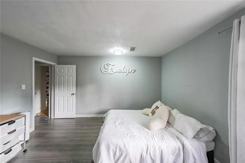 Bedroom featuring a textured ceiling and dark wood-style flooring