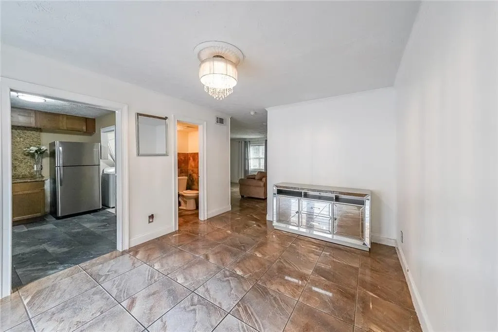 Unfurnished room with a chandelier and baseboards