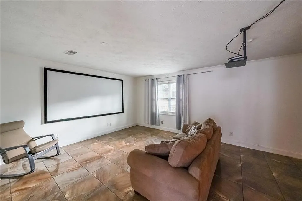 Cinema featuring a textured ceiling and baseboards