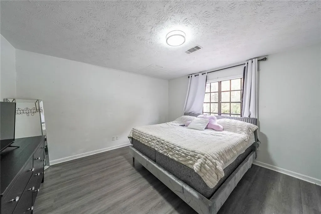 Bedroom featuring a textured ceiling and dark wood-style floors