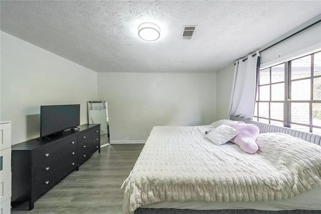 Bedroom featuring wood finished floors and a textured ceiling