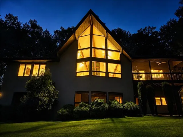 Exterior featuring a prominent A-frame window design, multiple windows, and a covered balcony with a ceiling fan