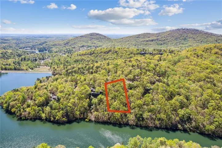 Aerial view of property and surrounding area featuring property boundaries highlighted and a water and mountain view
