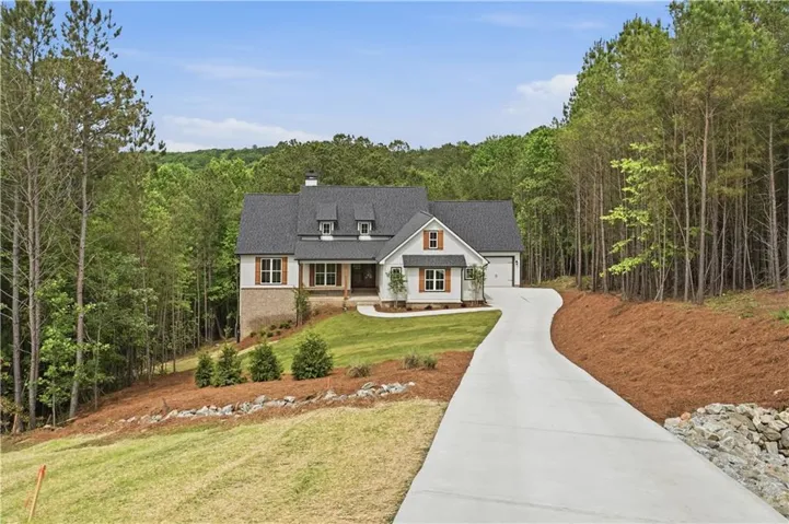 Contemporary exterior with a stone and siding facade, a dark shingled roof, a two-car garage, and a concrete driveway