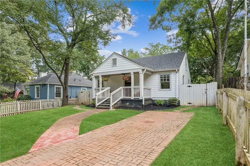 Bungalow-style house with roof with shingles, a gate, and a porch