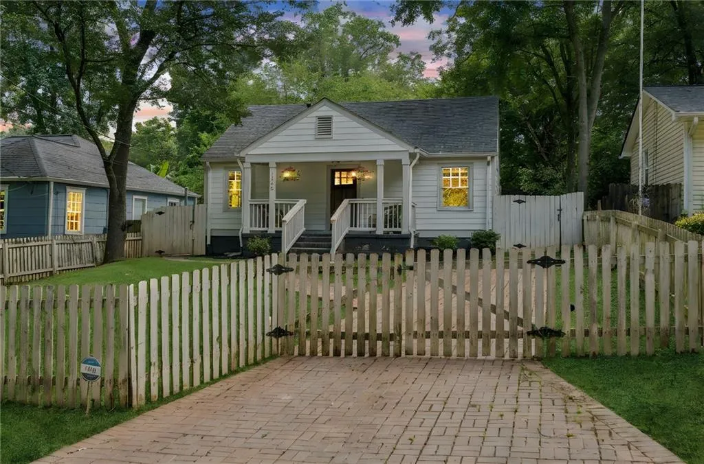 Bungalow-style house with a gate, covered porch, and a shingled roof