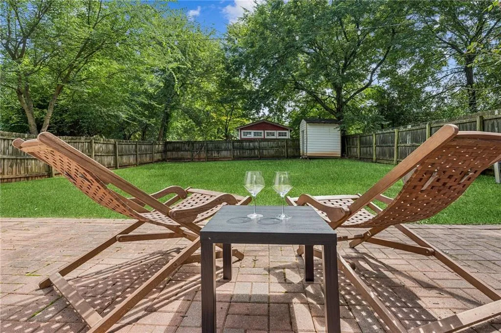 Fenced backyard featuring a patio area, outdoor dining space, and a storage shed
