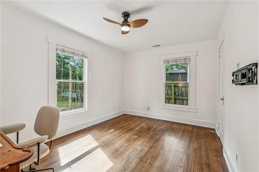 Office with dark wood finished floors and ceiling fan