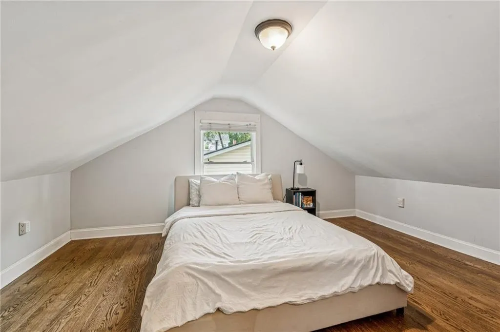 Bedroom featuring dark wood-style flooring and lofted ceiling