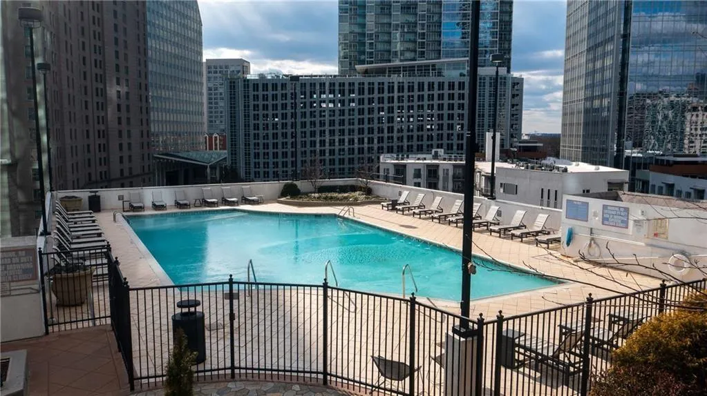 Community pool featuring a patio, a view of city, and fence