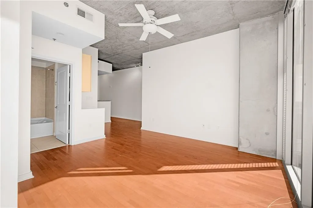 Spare room featuring visible vents, baseboards, wood finished floors, and a ceiling fan
