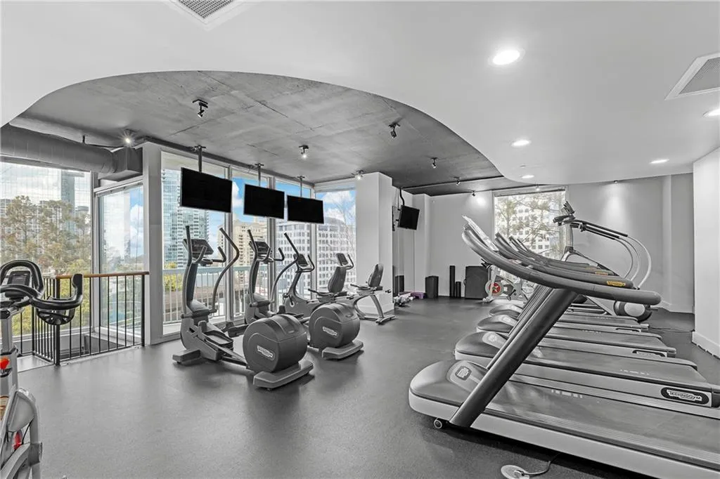 Gym with plenty of natural light, visible vents, baseboards, and expansive windows