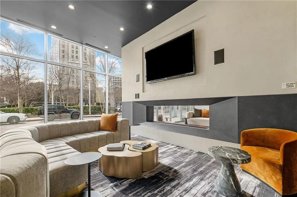 Living room with a wall of windows, visible vents, wood finished floors, and recessed lighting