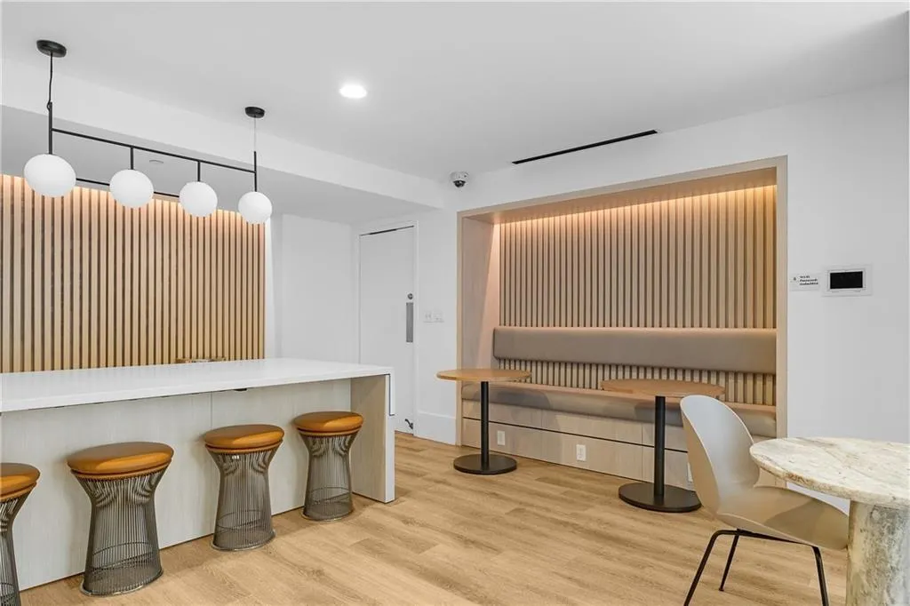 Kitchen with wood finished floors, visible vents, recessed lighting, a kitchen bar, and decorative light fixtures