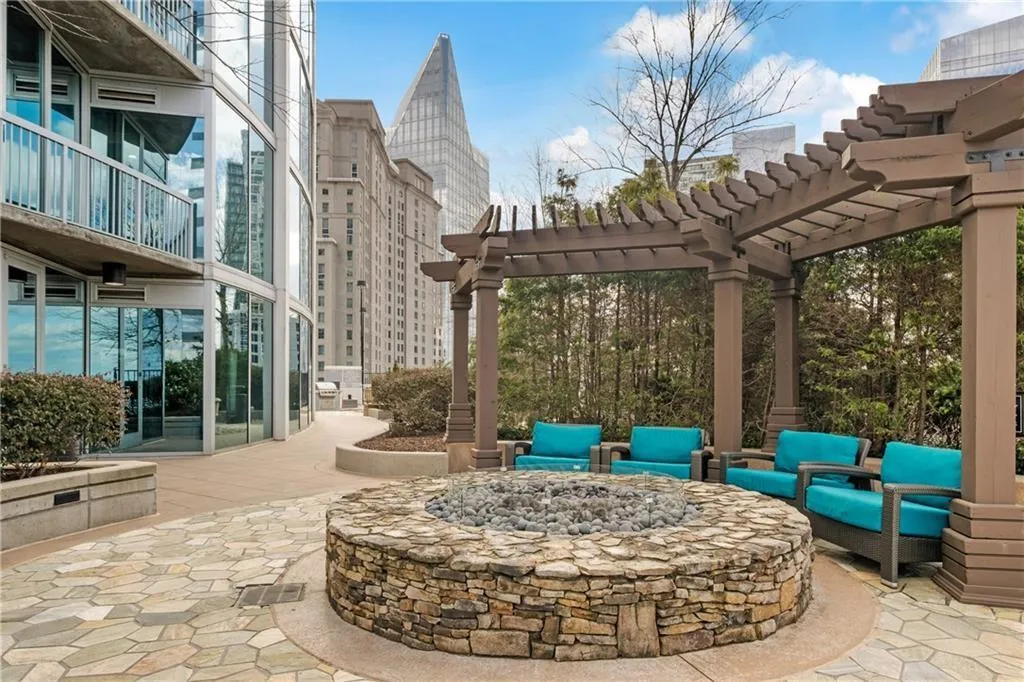 View of patio with a view of city, a pergola, and an outdoor living space with a fire pit