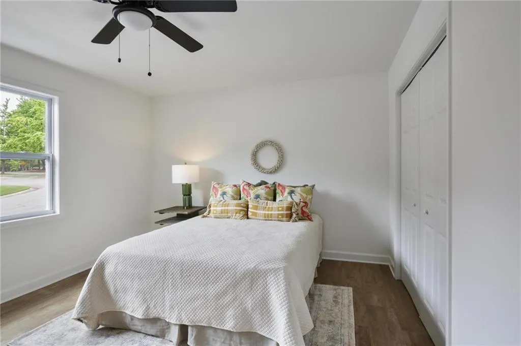 Bedroom with a closet, multiple windows, and wood-type flooring