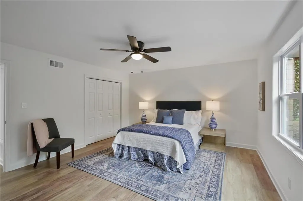 Bedroom featuring ceiling fan, light hardwood / wood-style flooring, and a closet
