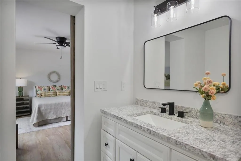 Bathroom with vanity, ceiling fan, and hardwood / wood-style floors