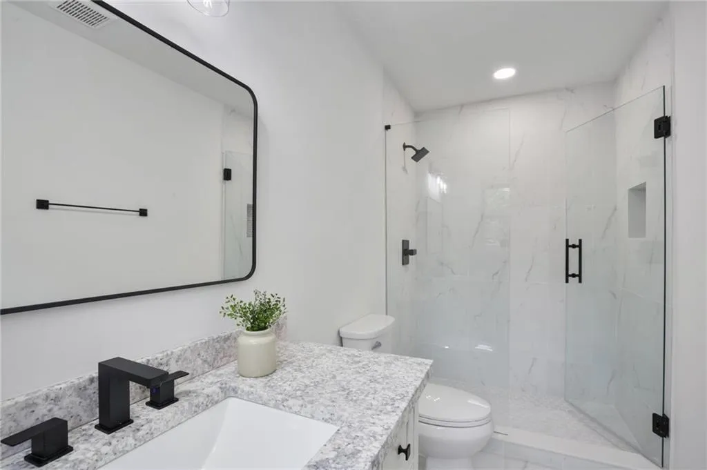 Bathroom featuring vanity, toilet, and walk in shower