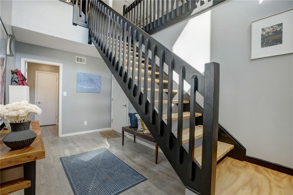 Stairs with light hardwood / wood-style floors and a high ceiling