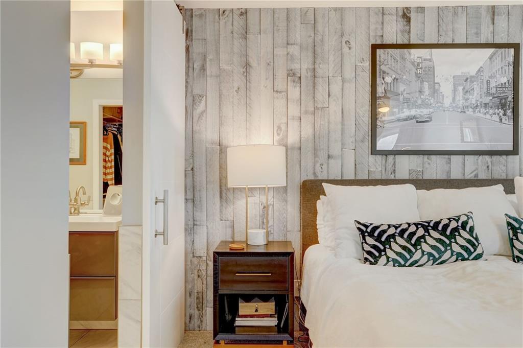 Bedroom featuring a walk in closet, a closet, ensuite bathroom, and sink