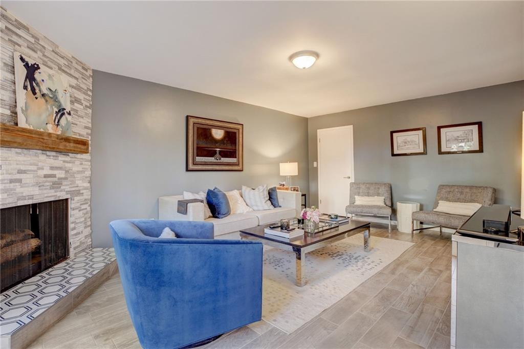 Living room featuring light hardwood / wood-style flooring and a stone fireplace