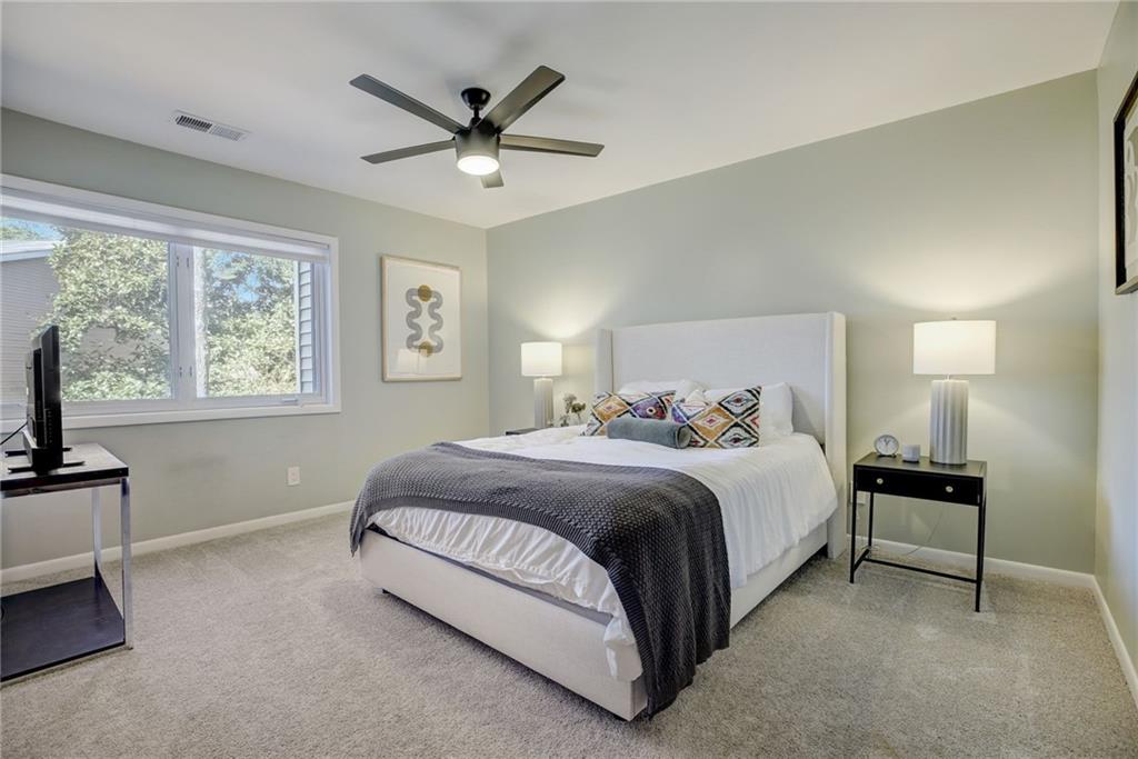 Carpeted bedroom featuring ceiling fan