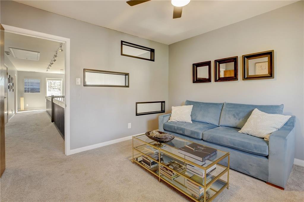 Living room featuring ceiling fan and light colored carpet