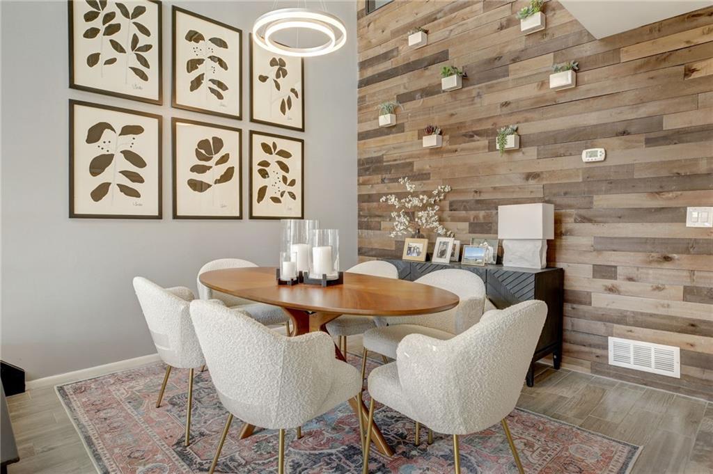 Dining room with dark hardwood / wood-style flooring and wood walls