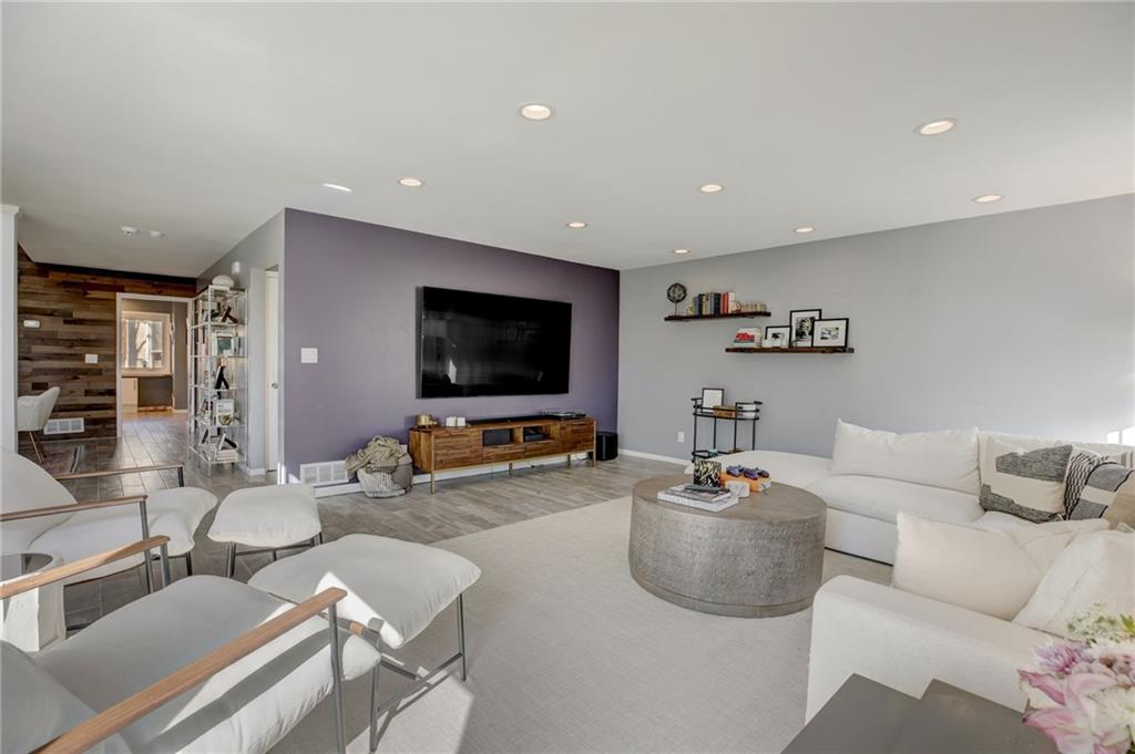 Living room with light hardwood / wood-style floors and wood walls