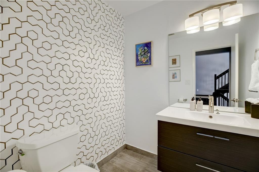 Bathroom featuring wood-type flooring, vanity, and toilet