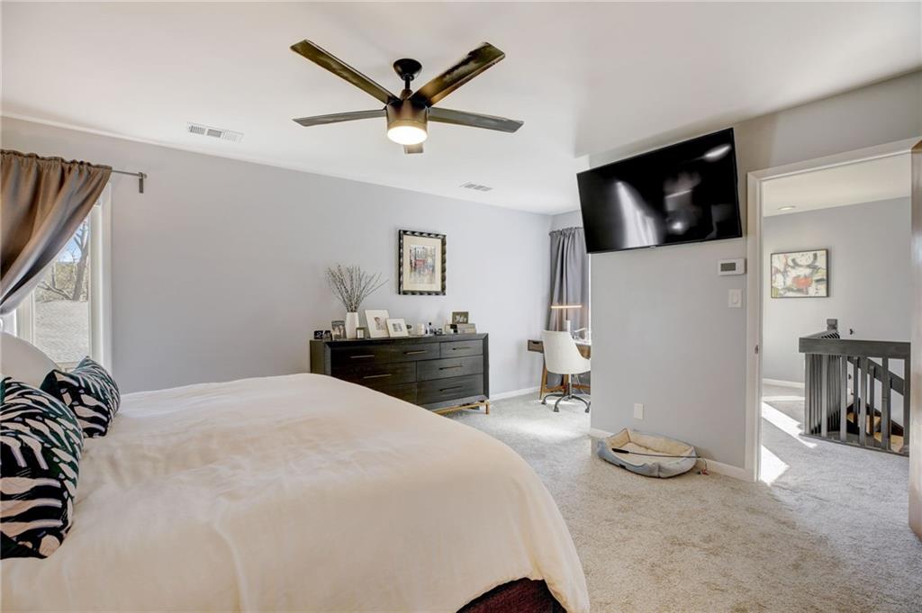 Carpeted bedroom featuring ceiling fan
