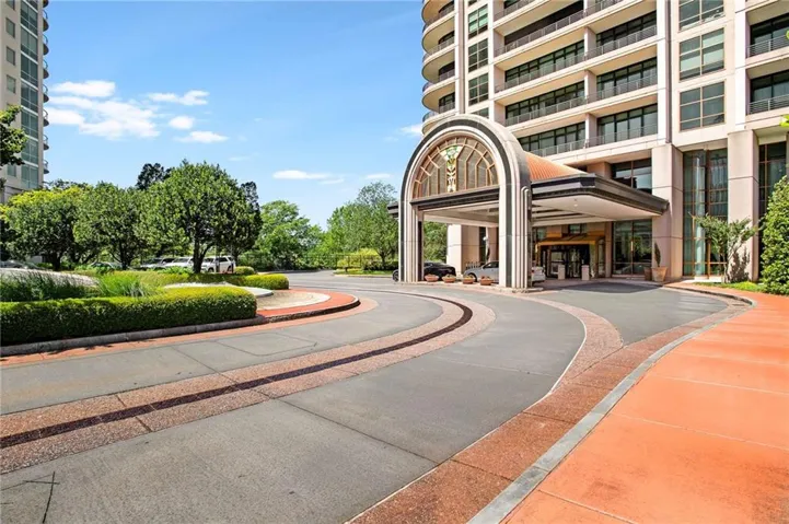 Circular drive with decorative paving, porte-cochere entry, and manicured landscaping