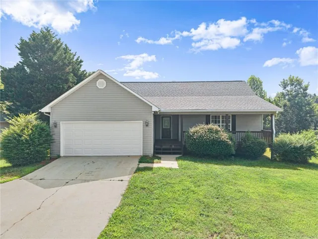 Single-story residence featuring a covered front porch, attached garage, and a gabled roofline