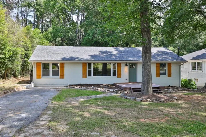 White exterior with wood shutters, gray shingle roof, and a teal front door
