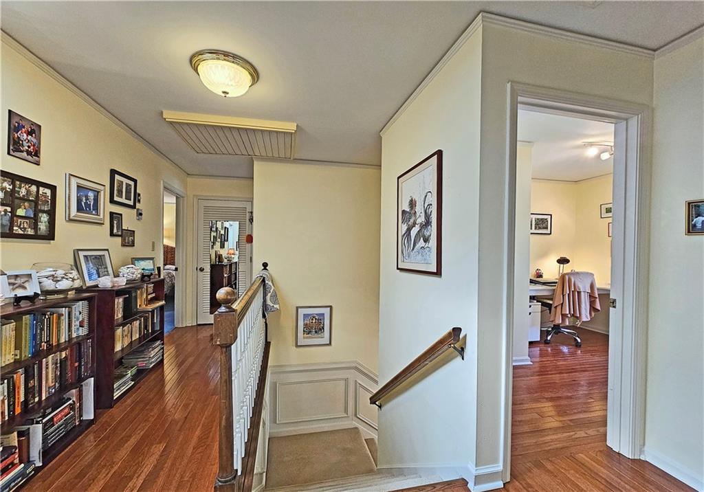 Stairway featuring dark hardwood / wood-style flooring and ornamental molding
