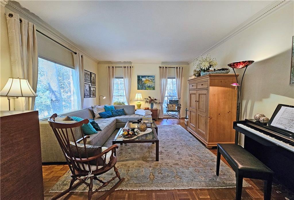 Living room featuring crown molding and dark parquet floors