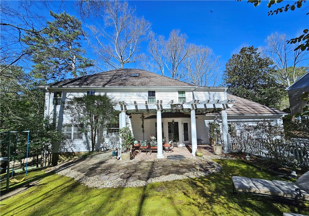 Rear view of house featuring a pergola, a yard, and a patio