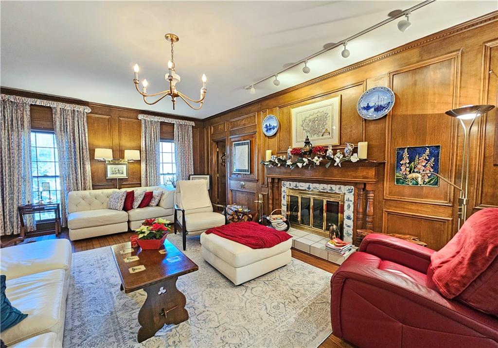 Living room with plenty of natural light, wooden walls, and a notable chandelier