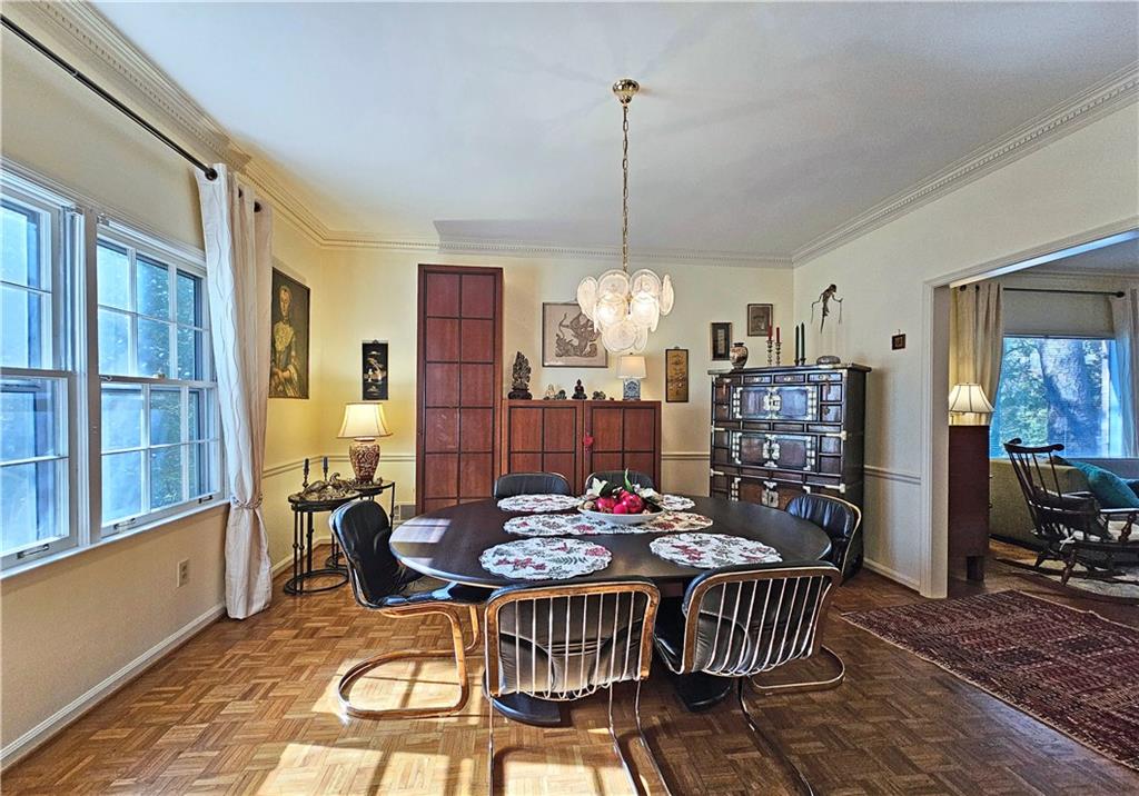 Dining space featuring a chandelier, a wealth of natural light, and light parquet flooring
