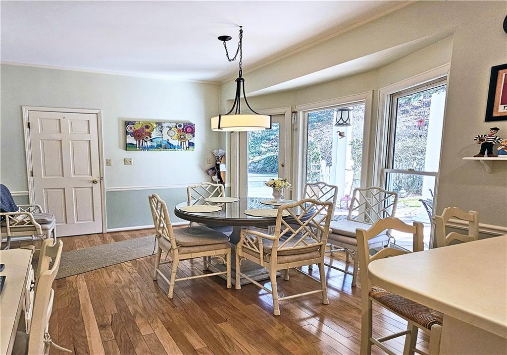 Dining room featuring dark wood-type flooring and ornamental molding