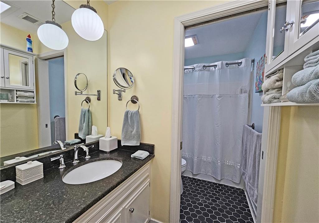 Bathroom featuring vanity, tile floors, and toilet