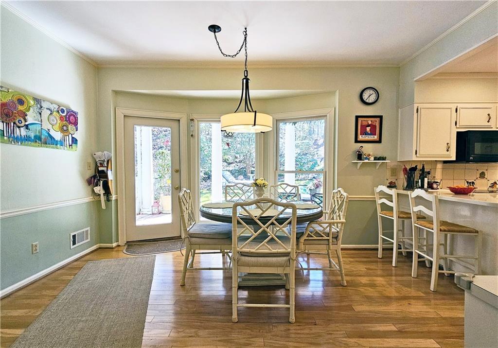 Dining area with hardwood / wood-style floors and ornamental molding