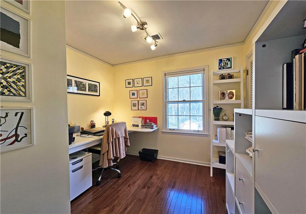 Office featuring dark hardwood / wood-style floors and track lighting