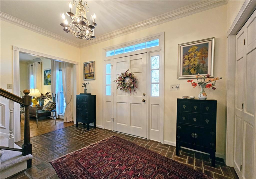 Entrance foyer featuring a notable chandelier and ornamental molding