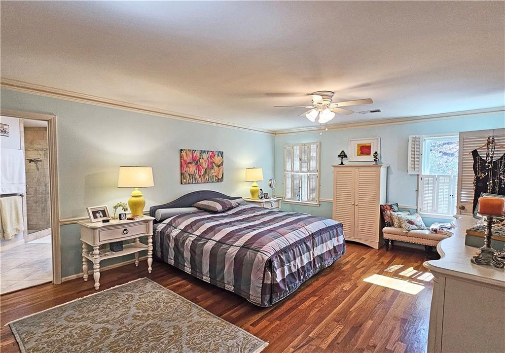 Tiled bedroom with crown molding and ceiling fan
